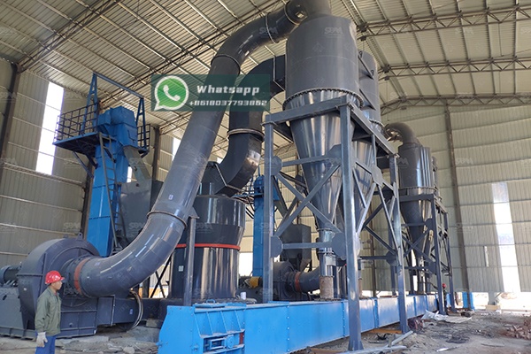 Modern proppant manufacturing facility with grinding equipment in background