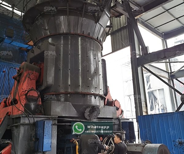 Technician performing maintenance on vertical mill feeding system components