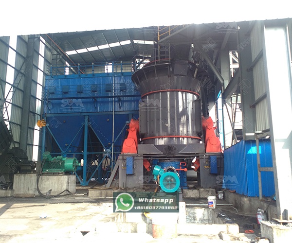 A modern vertical grinding mill in an industrial setting, showcasing its compact design and control systems.